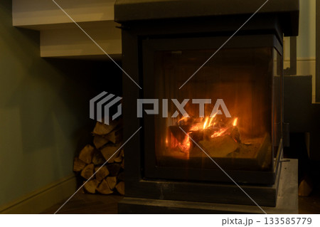 burning wood in the fireplace. the cozy atmosphere of a country house. burning wood in the fireplace. the cozy atmosphere of a country house. 133585779