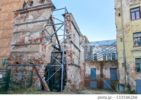 Historic brick building ruins with metal support frames in Old Riga, Latvia, under restoration 133586266
