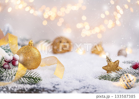 Golden Christmas Bauble on Snow with Ribbon and Lights Golden Christmas Bauble on Snow with Ribbon and Lights 133587385