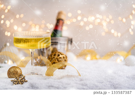 Champagne Glass and Bottle on Snow with Festive Lights Champagne Glass and Bottle on Snow with Festive Lights 133587387