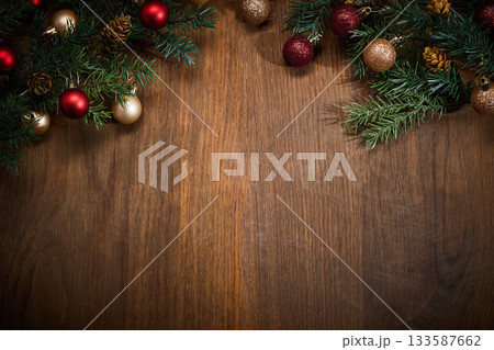 Christmas Decorations on Wood. Festive pine branches and baubles on a wooden surface. Christmas Decorations on Wood. Festive pine branches and baubles on a wooden surface. 133587662
