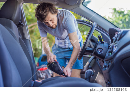 Man cleaning the interior of his car, wiping surfaces and organizing the vehicle, concept of cleanliness, maintenance and everyday routine 133588168