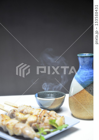 湯気の立ち昇る日本酒と焼き鳥 133588431