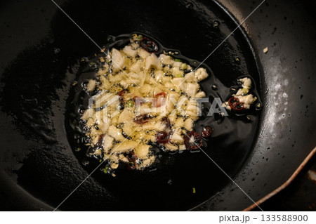ニンニクと唐辛子をオリーブオイルで炒める様子 133588900