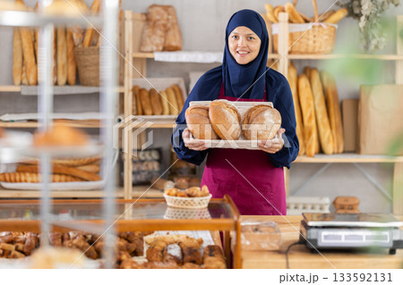 Asian Muslim woman bakery worker sells bread, stand at counter and wait for visitors 133592131