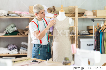 Young male tailor working with mannequin 133592145