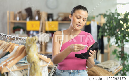 Beautiful asian woman chooses fashionable shoes in prestigious store Beautiful asian woman chooses fashionable shoes in prestigious store 133592170