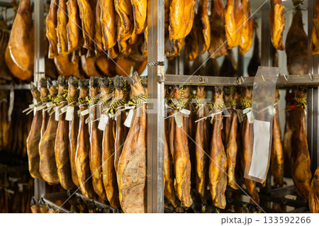 Legs of Spanish jamon ready for sale in grocery 133592266