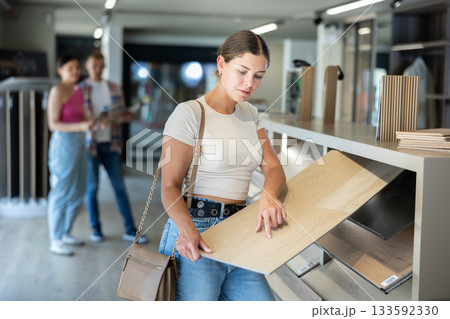 Young woman choosing laminate flooring in store 133592330