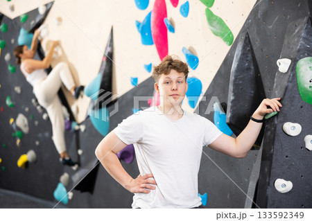 Teen guy posing against climbing wall Teen guy posing against climbing wall 133592349