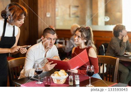 Waitress takes order from couple young man and woman Waitress takes order from couple young man and woman 133593043