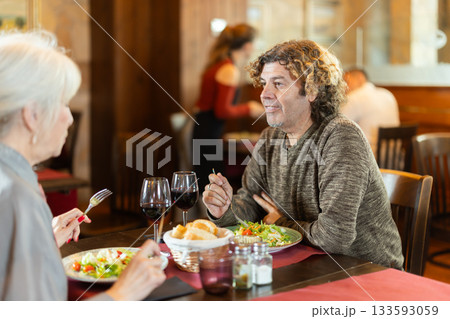 Couple elderly woman and adult man in restaurant Couple elderly woman and adult man in restaurant 133593059