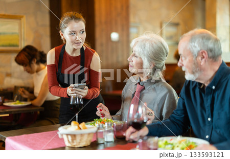 Waitress takes order from couple elderly man and woman 133593121
