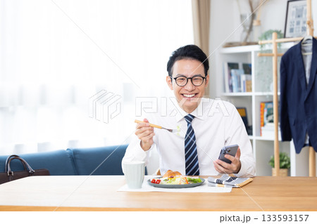 出勤前　スマホを見ながら食事をする男性 133593157