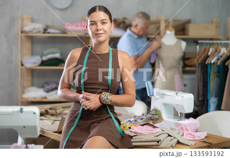 Young woman posing male assistant working with mannequin in workshop 133593192