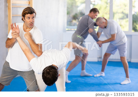 Young guy and man practice wrestling, apply techniques of Aikido and self-defense. 133593315