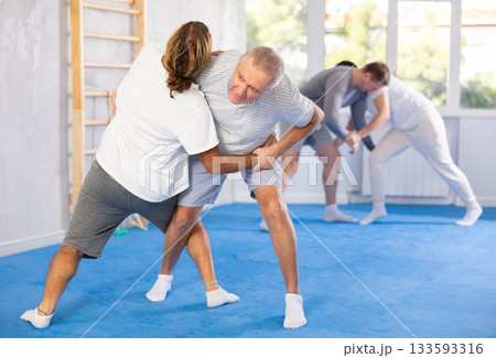 Elderly man learns to do a painful hold in self defense classes 133593316
