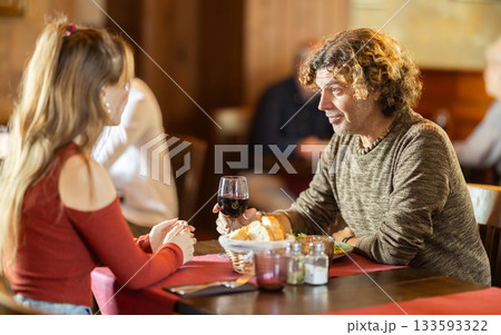 Happy young couple enjoying dinner together in restaurant Happy young couple enjoying dinner together in restaurant 133593322