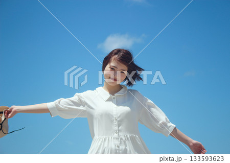 青空の下で手を広げる女性 133593623