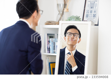 朝　鏡を見ながら身支度を整えるミドル男性 133594008