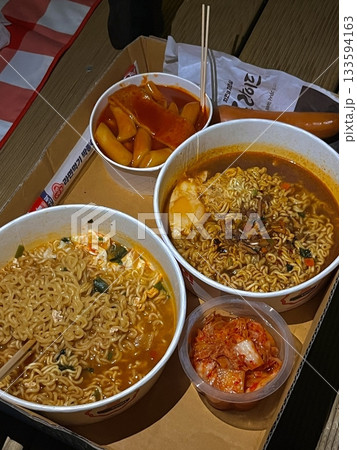 Steaming hot ramyun with rich, savory broth and chewy noodles, paired with spicy, tangy kimchi. A perfect Korean comfort food combination, balancing bold flavors and satisfying textures. 133594163
