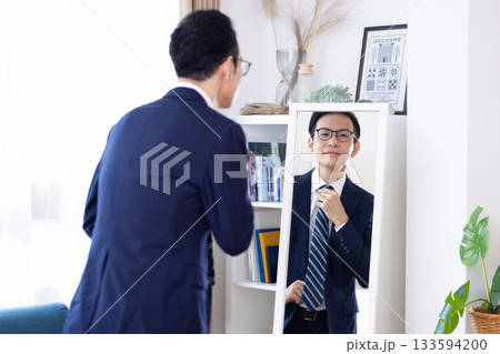 朝　鏡を見ながら身支度を整えるミドル男性 133594200