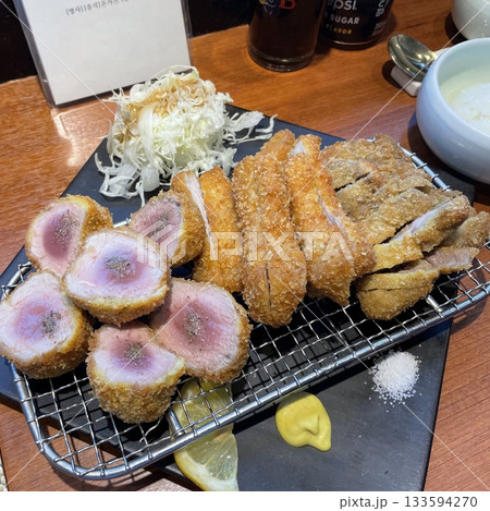 Crispy tonkatsu, a Japanese-style breaded and deep-fried pork cutlet, served with shredded cabbage and drizzled with savory sauce. A delightful balance of crunchy texture and juicy meat. Crispy tonkatsu, a Japanese-style breaded and deep-fried pork cutlet, served with shredded cabbage and drizzled with savory sauce. A delightful balance of crunchy texture and juicy meat. 133594270