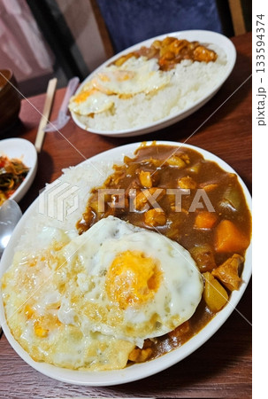 A comforting bowl of Japanese curry, featuring a rich, savory sauce with tender vegetables and chunks of meat, served over fluffy rice. A warm, flavorful dish perfect for any meal. 133594374