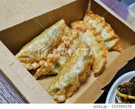 Delicious Korean mandu dumplings with a golden, crispy exterior and flavorful filling. Perfect as an appetizer, snack, or side dish, offering a delightful taste in every bite. 133594379