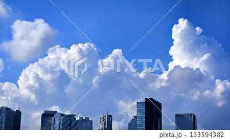 Sky view adorned with towering buildings, captured from below. The perspective showcases the majestic structures blending harmoniously with stunning clouds and a vibrant, clear sky. Sky view adorned with towering buildings, captured from below. The perspective showcases the majestic structures blending harmoniously with stunning clouds and a vibrant, clear sky. 133594382