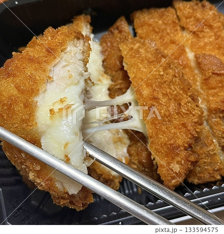 Crispy tonkatsu cutlet stuffed with melted cheese, creating a savory blend of crunch and creaminess. A comforting and satisfying dish with a rich, golden finish. Crispy tonkatsu cutlet stuffed with melted cheese, creating a savory blend of crunch and creaminess. A comforting and satisfying dish with a rich, golden finish. 133594575