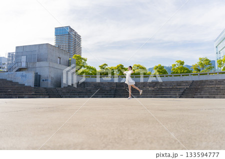 野外競技場でジャンプする女性 133594777