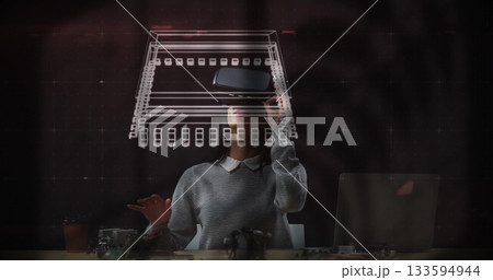 Gesturing female engineer manipulating holographic circuit schematic at lab desk, with AR headset Gesturing female engineer manipulating holographic circuit schematic at lab desk, with AR headset 133594944