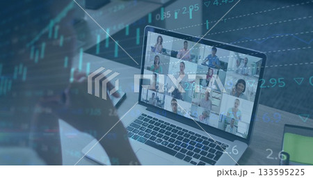 Watching person wearing shirt monitoring laptop grid at desk, with smartphone and financial charts 133595225