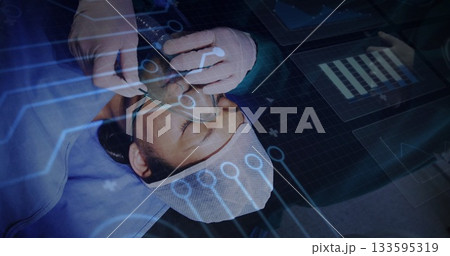 Positioning oxygen mask over male patient face in operating room, with digital interface overlay Positioning oxygen mask over male patient face in operating room, with digital interface overlay 133595319