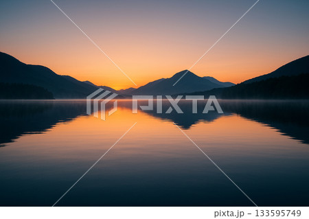 朝焼けに包まれた静かな山の湖 133595749