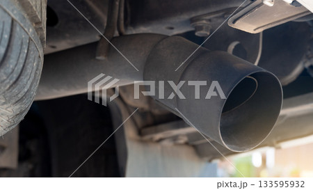 Underneath the car. Exhaust pipe cover for automobiles. Part of the car equipment is covered with dust. making the object cloudy. Underneath the car. Exhaust pipe cover for automobiles. Part of the car equipment is covered with dust. making the object cloudy. 133595932