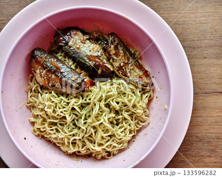 Instant noodles with spicy canned fish in a pink bowl, simple budget meal. Instant noodles with spicy canned fish in a pink bowl, simple budget meal. 133596282