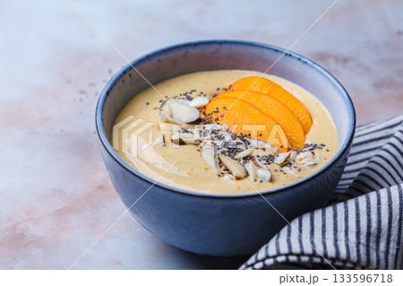 Persimmon smoothie bowl with chia seeds and nuts. 133596718