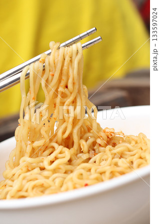 Spicy instant noodles bowl eating and hand 133597024