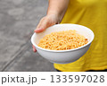 Spicy instant noodles bowl and hand 133597028