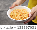 Spicy instant noodles bowl and hand 133597031