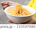 Spicy instant noodles bowl eating and hand 133597080
