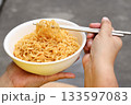 Spicy instant noodles bowl eating and hand 133597083