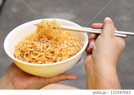 Spicy instant noodles bowl eating and hand Spicy instant noodles bowl eating and hand 133597083