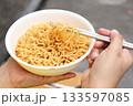 Spicy instant noodles bowl eating and hand 133597085