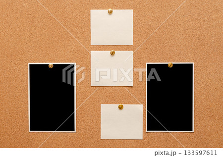 Blank paper notes and an empty photo are pinned to a cork board. The concept of detective investigation. Blank paper notes and an empty photo are pinned to a cork board. The concept of detective investigation. 133597611