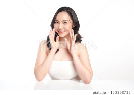 A beautiful young Asian woman with clean, fresh skin against a white background. Skincare, facial treatment, cosmetology, beauty, and spa. An elegant portrait of an Asian woman. 133598733