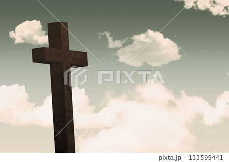 Flat design art is showing tall wooden cross rising against soft green sky with cream clouds 133599441