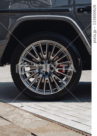Close-up view of a luxury vehicle wheel on a modern pavement 133600626